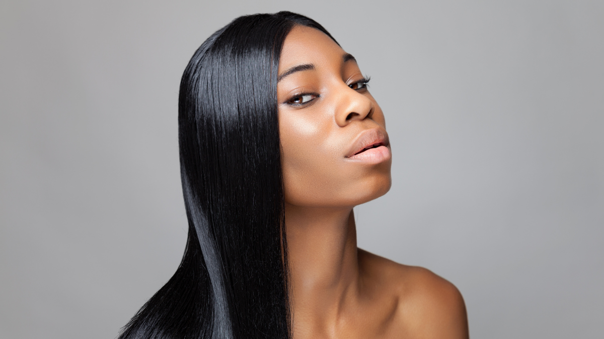 Close-up of a woman with long straight black hair and flawless finish